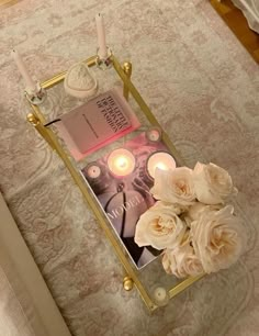 a tray with candles and flowers on a bed