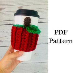 a hand holding a coffee cup sleeve with a knitted apple on it and the text, free crochet pattern