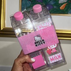 a person holding two water bottles with hello kitty stickers on them