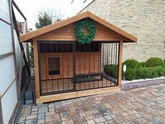 a dog house with a wreath on the top and door open to let in some air