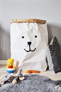 a white paper bag with a bear face on it next to toys and other items