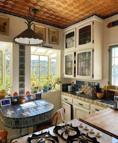 a kitchen with a stove top oven sitting next to a window filled with lots of windows