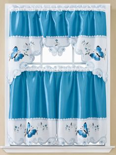 a window with blue curtains and butterflies on it