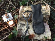 a pair of black shoes sitting on top of a tree stump next to a lantern