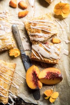 peach pie with icing and sliced peaches on parchment paper next to a knife