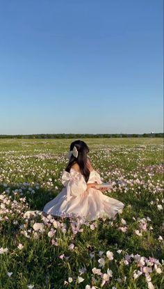 a woman sitting in a field with flowers