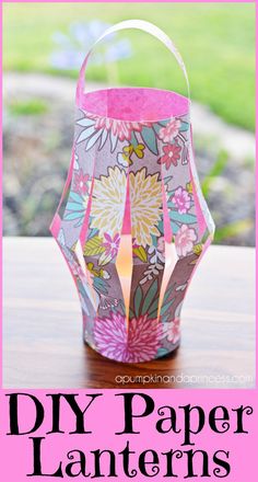 a paper lantern sitting on top of a table next to a pink flowered candle