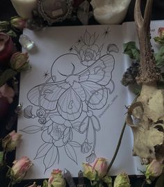 a drawing on paper surrounded by flowers and candles