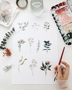 someone is painting flowers with watercolors on paper