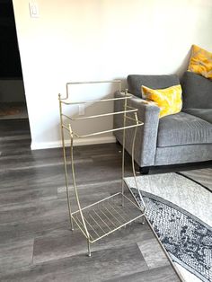 a living room with a gray couch and yellow throw pillows on the floor next to a grey chair