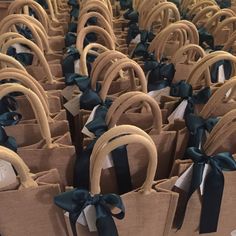 many brown bags with blue bows are lined up