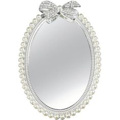 a white mirror with pearls and bows on the top, in front of a white background