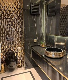 a bathroom with black and gold decor on the wall, sink and mirror in it