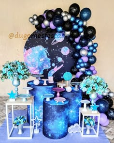 a space themed birthday party with balloons and decorations on the table, including vases filled with flowers