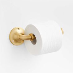 a roll of toilet paper hanging from a gold - plated metal wall mounted holder