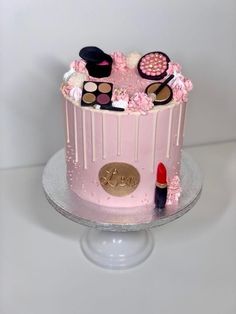 a pink cake decorated with makeup and lipstick