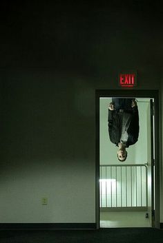 a person hanging upside down in an exit way