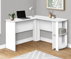 a white corner desk with a laptop on it and a plant in front of it