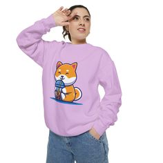 a woman wearing a pink sweatshirt with an image of a cat holding a tennis racket