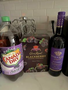 bottles of wine and other liquor sitting on a counter top next to a box of chocolates