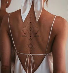 the back of a woman's neck with an intricate design on it