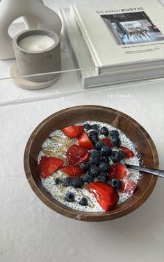 a bowl of oatmeal with strawberries and blueberries