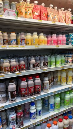 the shelves are filled with many different types of juices and drinks, including yogurt