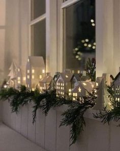 christmas lights are placed on the windowsill in front of a window sill with small houses