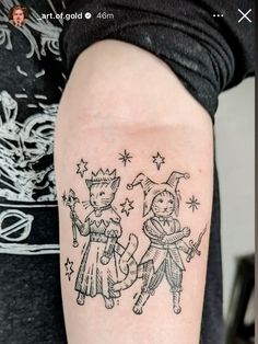 a woman with a tattoo on her arm that has two cats and a cat in the middle