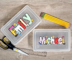 some pencils and scissors are sitting next to a plastic container with the word mom written on it