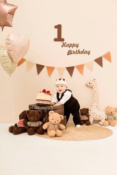 a baby is sitting on the floor surrounded by teddy bears and balloons with a 1st birthday banner in the background