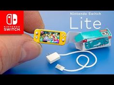 a nintendo wii lite is being held up by someone's hand, with the box attached to it