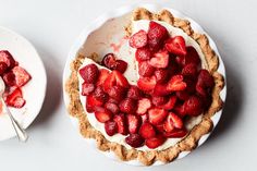 two pies with strawberries on them are sitting next to each other