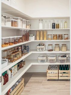 an organized pantry with white shelving and lots of food in containers on the shelves