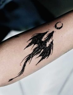 a woman's arm with a tattoo on it and a bird flying in the sky