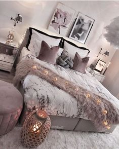 a bedroom with a large bed covered in furry blankets and lights on the headboard