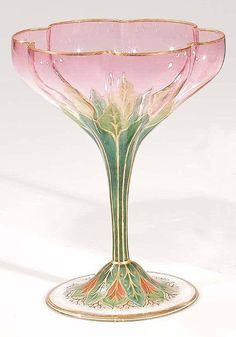 a pink and green glass vase sitting on top of a white table