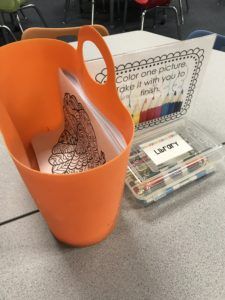 an orange vase sitting on top of a table next to a plastic container with scissors in it