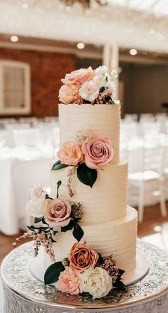 a three tiered wedding cake with pink and white flowers