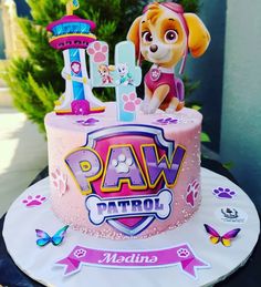 a pink cake with paw patrol decorations on it