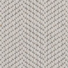 an up close shot of a white knitted fabric with small, wavy lines on it