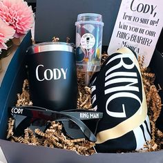 an open box with sunglasses, coffee and other items in it next to pink flowers