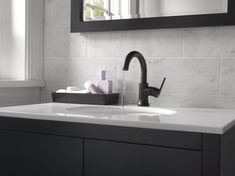 a bathroom sink sitting under a mirror next to a window