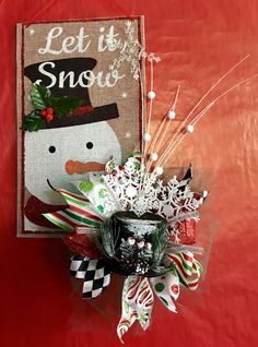 a snowman decoration with candy canes and christmas decorations in it on a red background