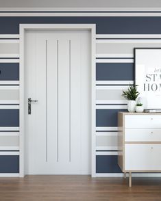 an empty room with blue and white stripes on the walls, a chest of drawers and a framed poster