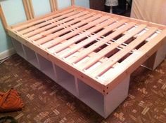 a wooden bed frame sitting on top of a hard wood floor next to a wall