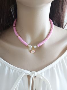 Pinkl necklace is an excellent and elegant gift for your lovelies. Heishi necklace is made of pink heishi bead, evil eye , pearl and gold plated apparatus. You can wear the beach necklace to a wedding party and look very special. Beach necklace is a nice Christmas gift, Valentine's Day gift, wedding gift, birthday gift, bridesmaid gift and other special day gift for her. Your necklace will be put in a nice tulle sachet. Heishi Beads Strand Necklaces As Gift, Heishi Bead Necklace With Heart Beads Gift, Gift Necklace With Heart Heishi Beads, Collier Heishi, Godmother Bracelet, Jewelry Pearl Necklace, Cross Stitch Necklace, Accessories Beach, Necklace Evil Eye