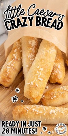 some bread sticks sitting on top of a cutting board next to a paper bag with the words, little cheeser's crazy bread ready in just 28 minutes