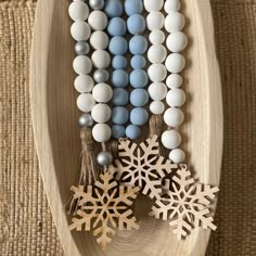 snowflakes, beads and tassels are arranged on a wooden boat