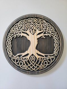 a wooden plaque with an intricate tree on it